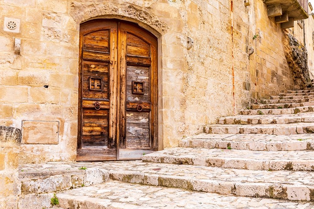 Italy-Basilicata-Province of Matera-Matera Old wooden door in a stone wall above stone steps